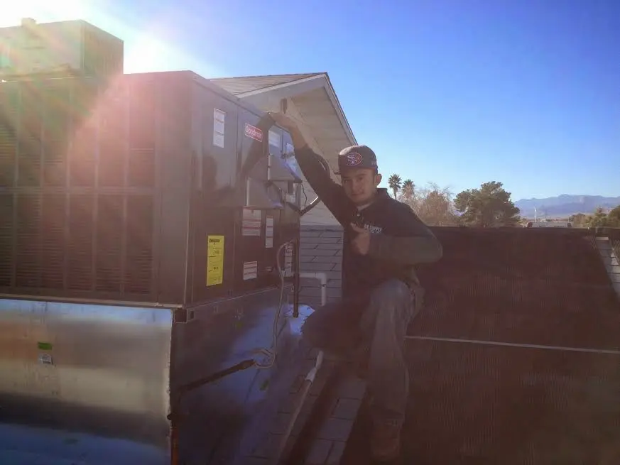 HVAC technician performing Air Duct Repair on a rooftop unit in Upland